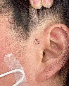 a person with a small tattoo on their ear