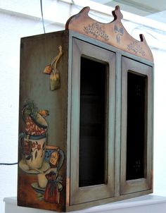 an old fashioned cabinet painted with cartoon characters on it's sides and two doors