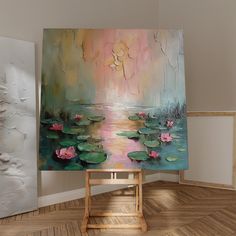 an easel with a painting on it in front of a wall and wooden floor