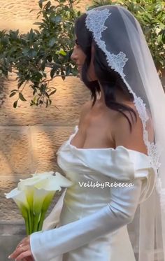 a woman in a wedding dress holding a white rose