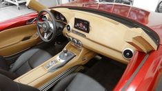 the interior of a red sports car with black leather and tan trims is shown