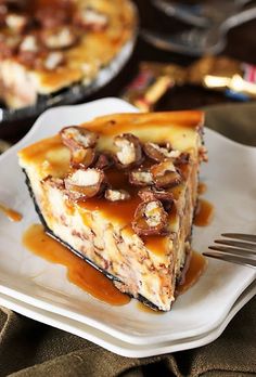 a slice of cheesecake on a white plate with caramel sauce and pecans