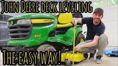 a man kneeling down next to a green lawn mower with the words john deere deck leveling the easy way