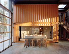 an open kitchen and living room with stairs leading up to the second floor in a shipping container