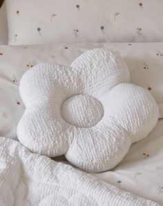 a white pillow sitting on top of a bed