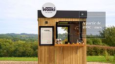 a small wooden kiosk sitting on top of a lush green field