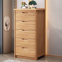 a wooden chest of drawers in a room with white walls and beige flooring on the side