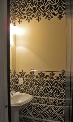 a white sink sitting under a bathroom mirror next to a wall mounted faucet