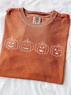 an orange shirt with three pumpkins on it