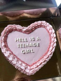 a cake shaped like a heart with words written on the top and bottom in pink frosting