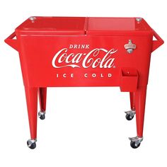 a coca cola cooler sitting on wheels with the lid open