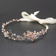 a tiara with flowers and pearls on the headband is laying on a black surface