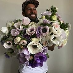 a man holding a large bouquet of flowers