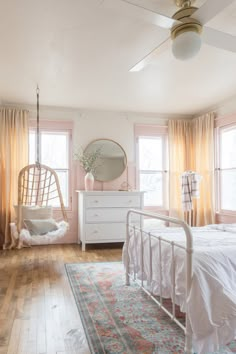 a bedroom with pink walls and white furniture