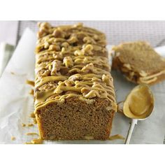 a close up of a loaf of cake with frosting on it and a spoon next to it