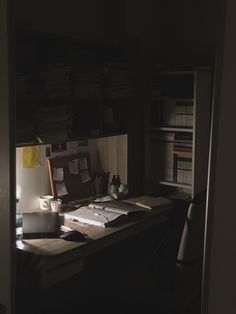 an office desk is lit up by the light of a lamp on top of it