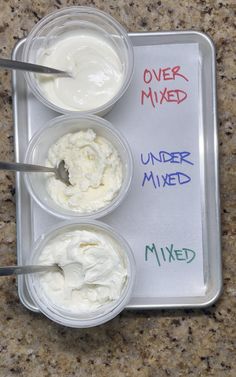 three containers filled with whipped cream on top of a counter next to a sign that says over mixed