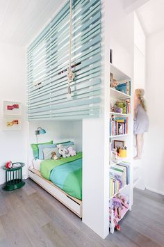 a child's bedroom with bunk bed and bookshelf in the corner,