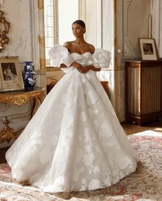 a woman in a white wedding dress posing for the camera