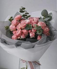 a bouquet of pink roses is wrapped in paper