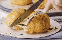 a person is cutting into some food on a plate with a large knife in it