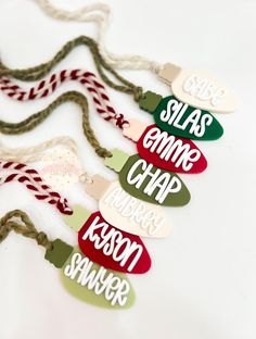 six christmas tags with words on them hanging from twine cord, one says sleas game crap merry krasset shaver