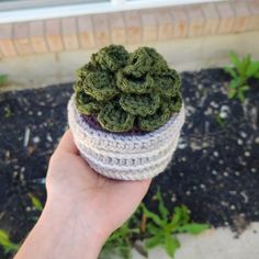 a hand holding a crochet potted plant