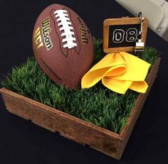 a football sitting on top of green grass next to a wooden box with a keychain