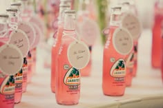 pink bottles with labels on them sitting on a table