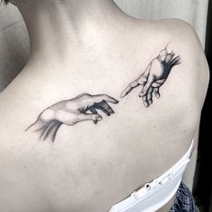 a woman with a tattoo on her shoulder holding the hands of two different people's hands