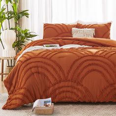 an orange comforter and pillows in a bedroom