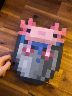 someone is making a paper cut out of the head of an animal with different colored squares on it