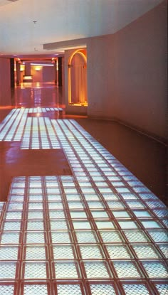 the floor is made up of squares and glass tiles in an empty room with lights on either side