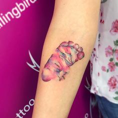 a tattoo on the arm of a woman with a pink and blue animal print design