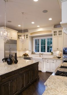 a large kitchen with an island in the middle and marble counter tops on both sides