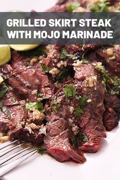 grilled skirt steak with mojo marinade on a white plate next to lime wedges