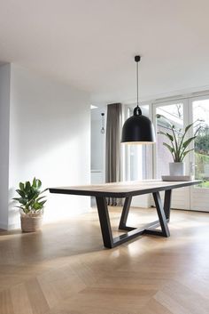 an empty room with a table and potted plants