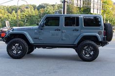 a blue jeep is parked in a parking lot