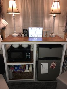 a table with a sign on it and two lamps next to it in a living room