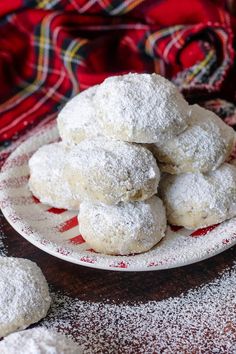 powdered sugar cookies are piled on a plate