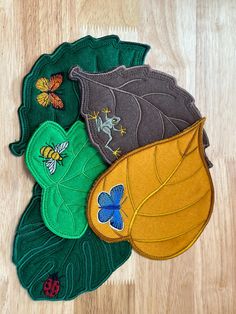 three leaf shaped appliques on top of a wooden floor