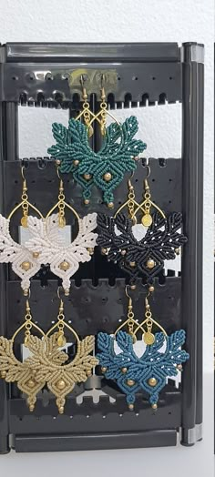 several pairs of earrings are hanging on a rack