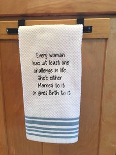 a white towel hanging from a hook on a wooden door with a poem printed on it