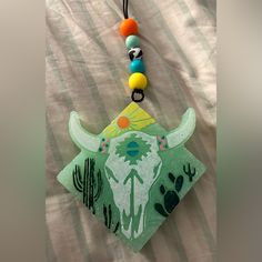 a necklace with a cow head on it and beads hanging from the end of it