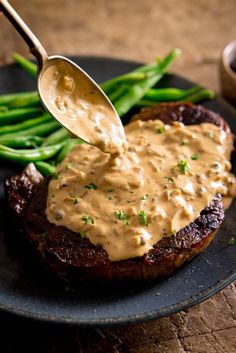 a fork is being used to dip sauce on a steak