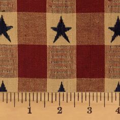 a ruler is next to a red and white checkered fabric with stars on it