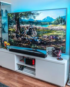 a flat screen tv sitting on top of a white entertainment center in a living room