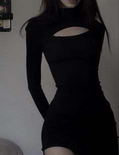 a woman in a black dress posing for the camera with her hands on her hips