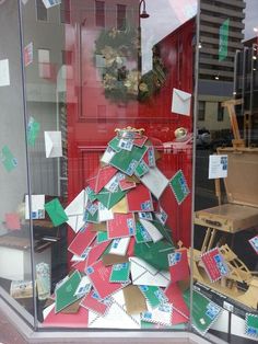 a christmas tree made out of mail sitting in front of a red door