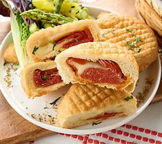 a sandwich cut in half sitting on top of a white plate next to a basket